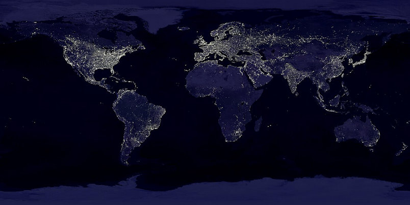 Nighttime satellite view of Earth showing illuminated cities across continents