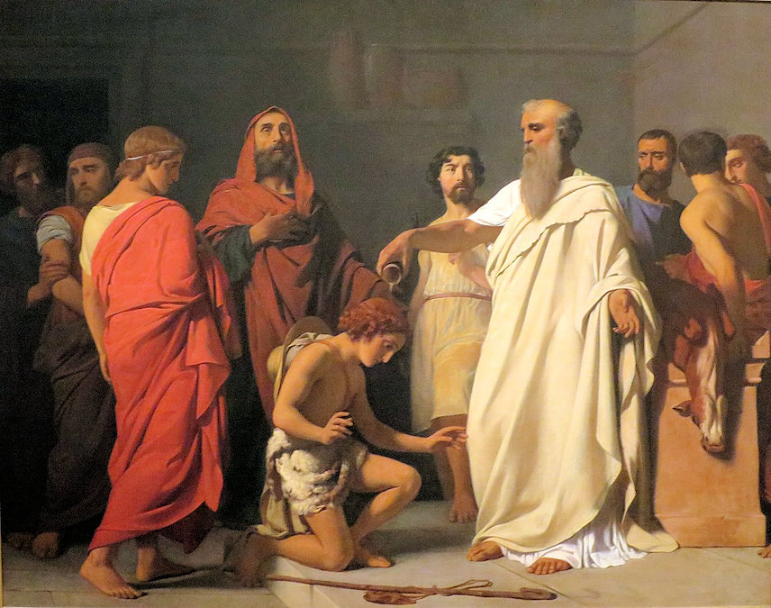 An older man pours oil on the head of a kneeling boy with a group of others watching