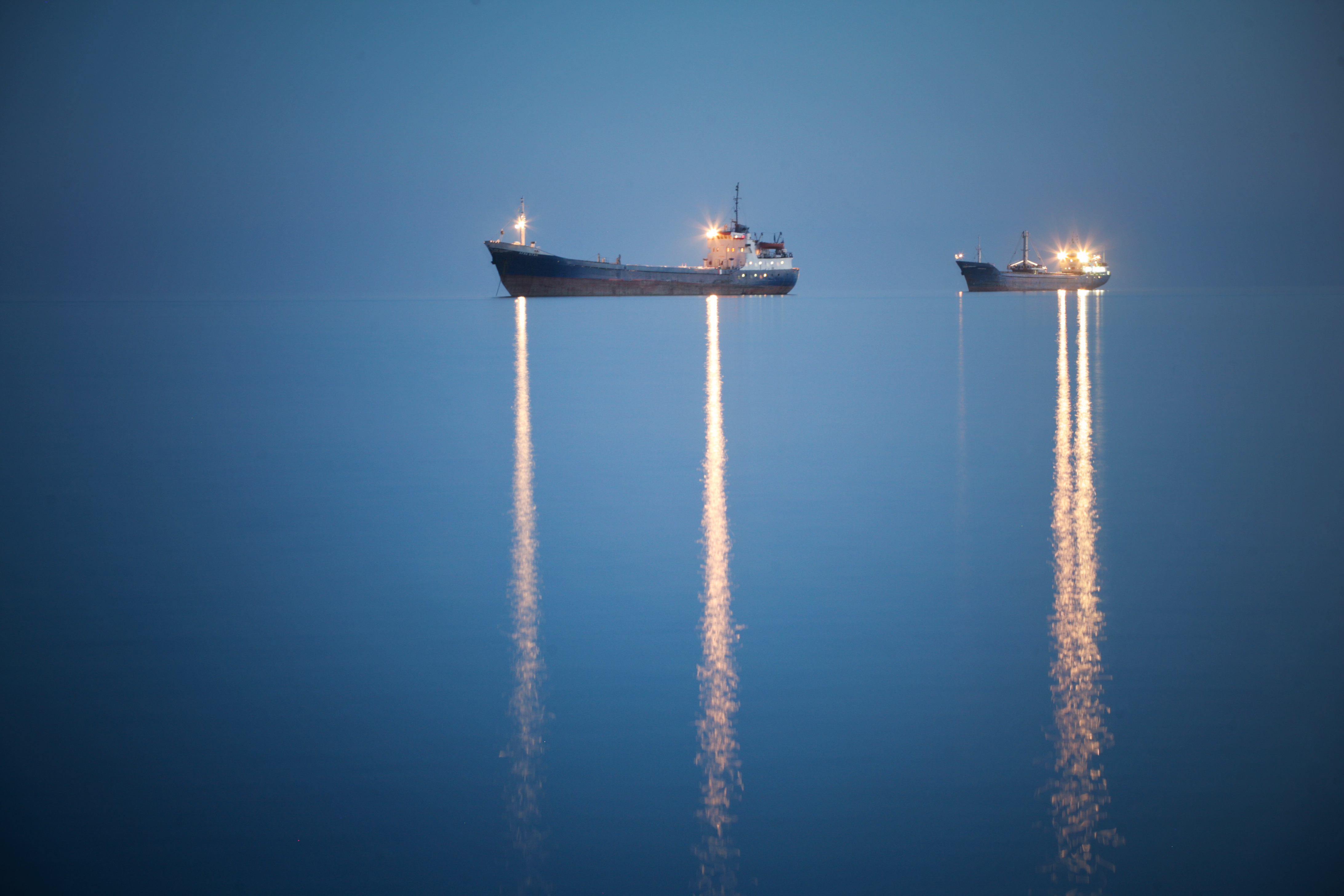 Two ships look like they are flying through the air rather than sitting in the water