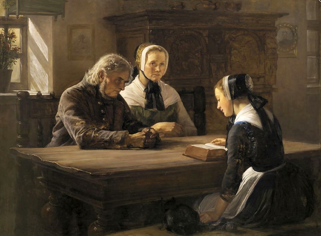 Young lady seated at a table reading the Bible to two older people