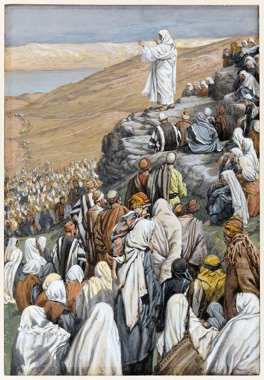 Jesus standing on a rock on a hillside preaching to a huge crowd