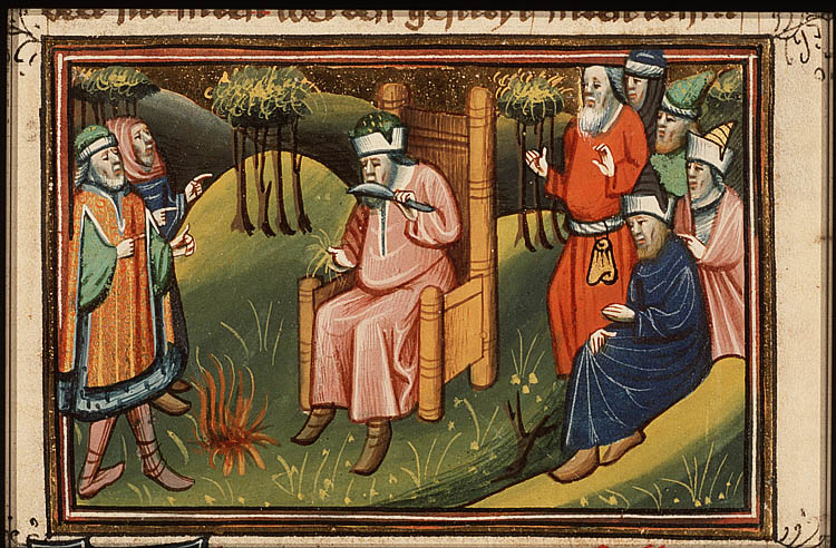 Man seated cutting off hair and throwing it into a fire