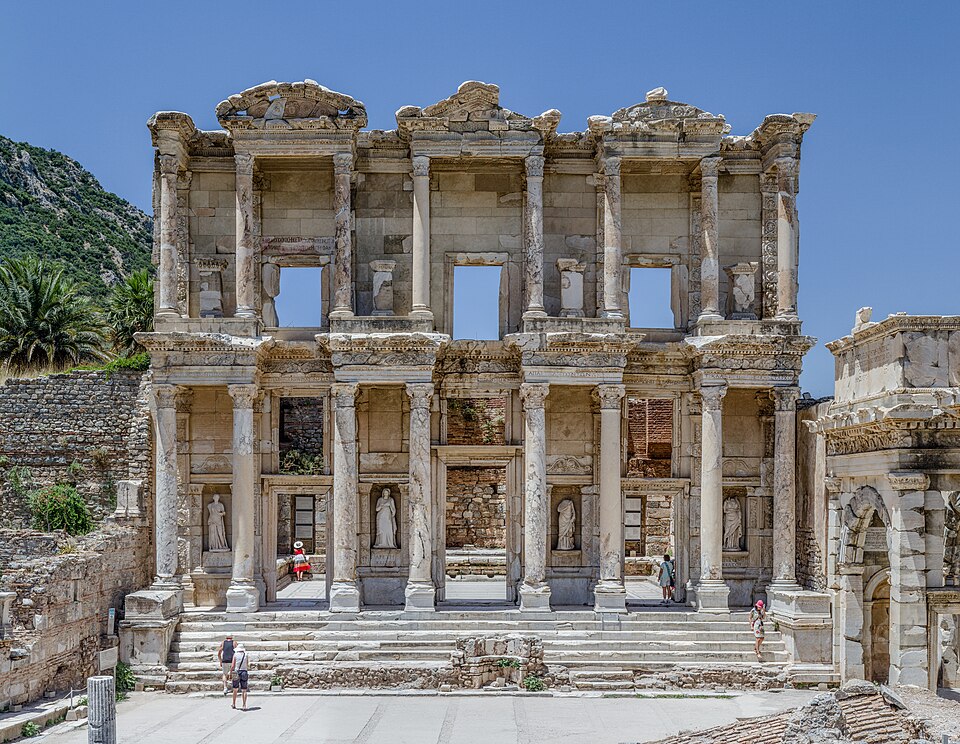 Facade of the Celsus Library in ancient Ephesus — a two-story stone building with multiple windows and doorways