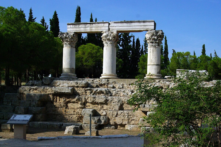 Three ornate stone columns with an architrave across the top of all three