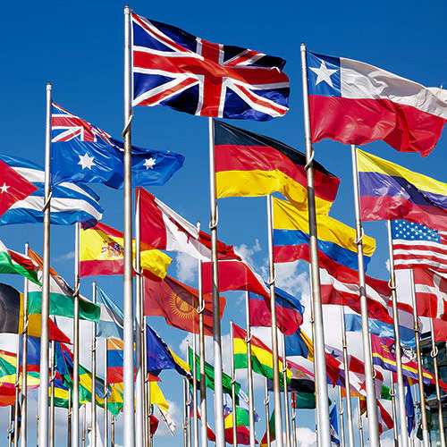 flags of many different countries on tall flagpoles