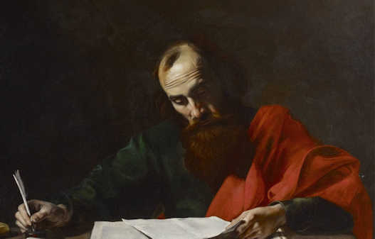 Paul sitting at a table writing letters