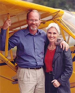 Steve and Ginny Saint standing under the wing of a small airplane