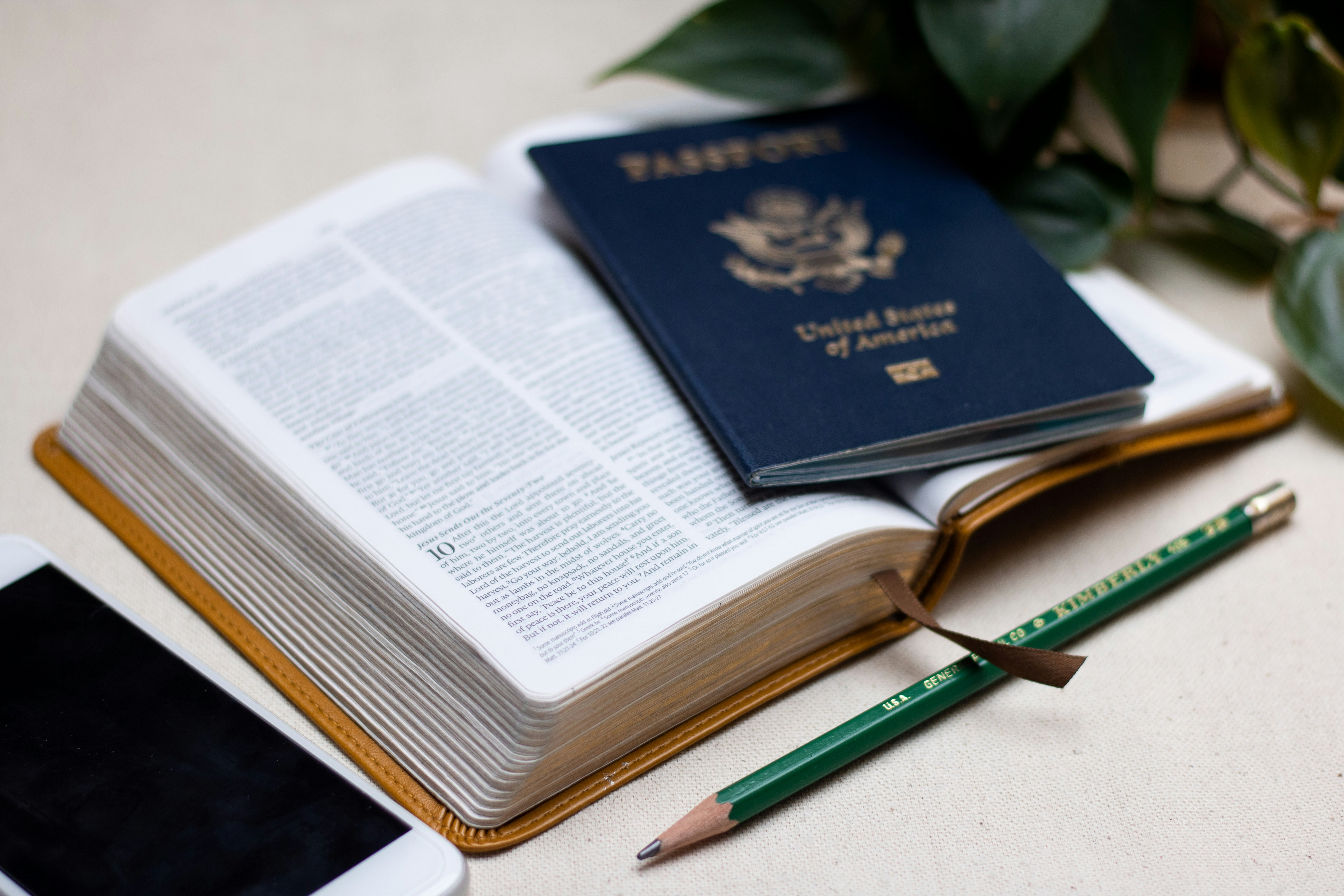 Passport, cellphone and Bible on a table