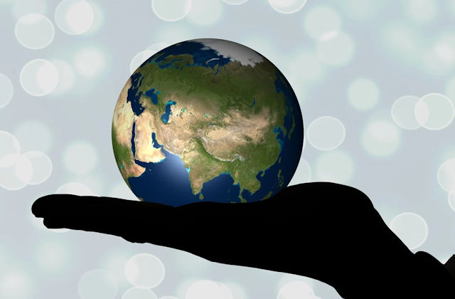 a globe showing Asia in the palm of a human hand